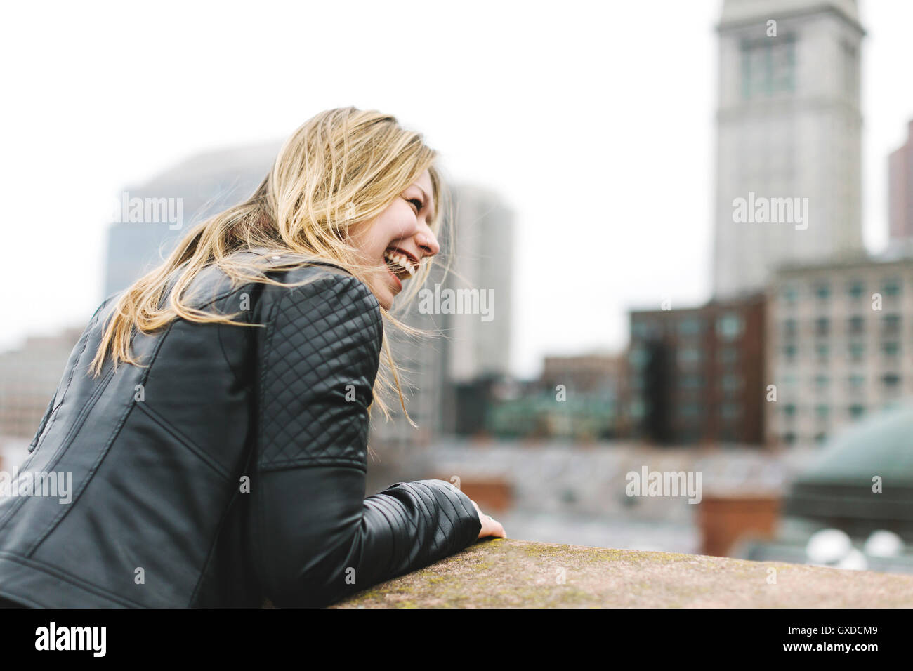 Femme sur le toit à l'écart smiling, Boston, Massachusetts, USA Banque D'Images