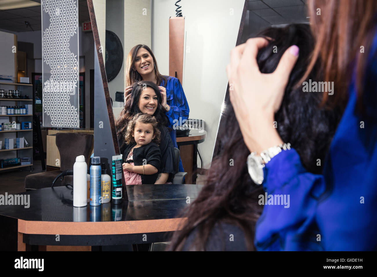 Styliste assistant à au client dans un salon de coiffure Banque D'Images