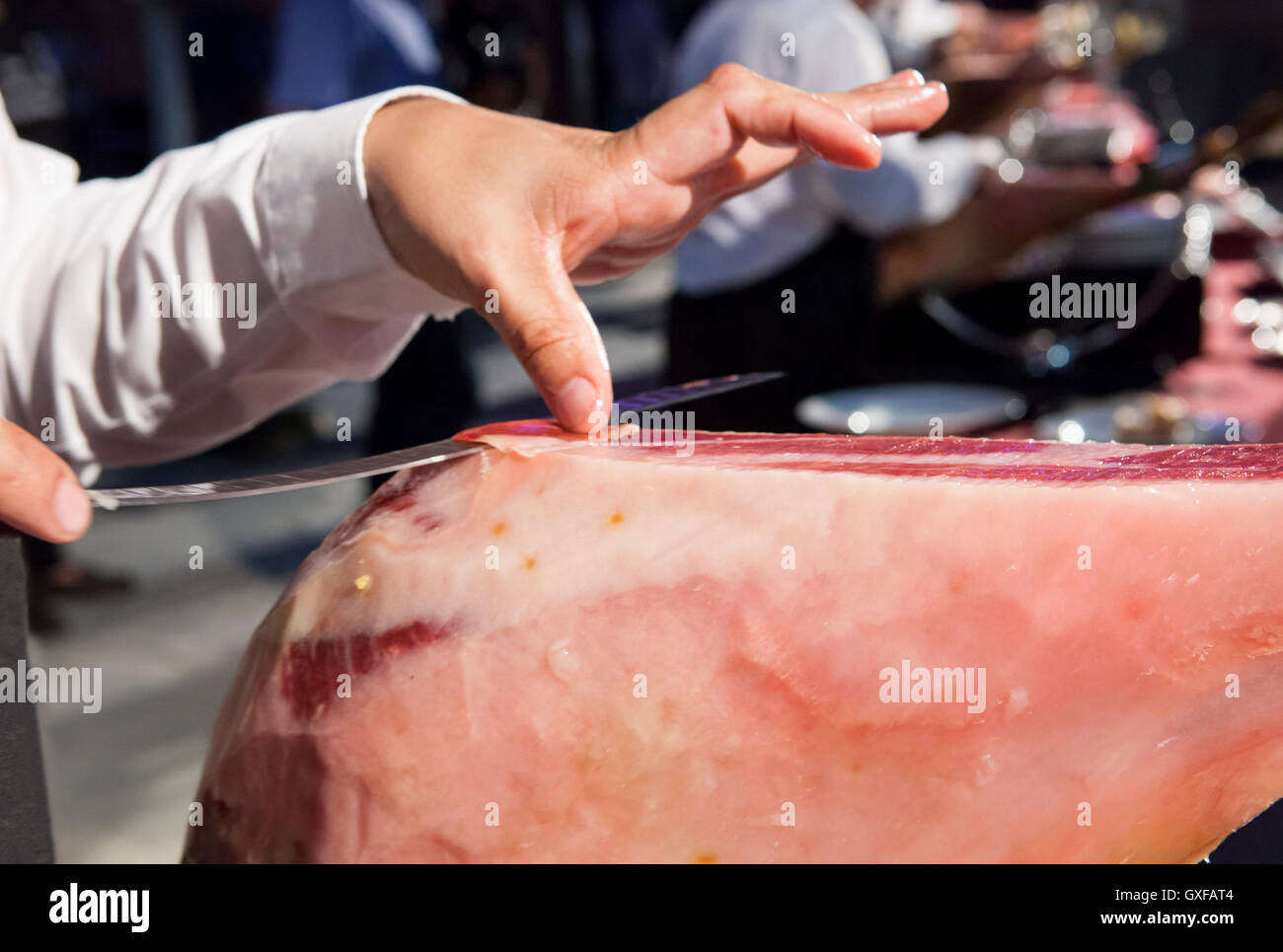 Tranche-maître est titulaire de la tranche de jambon ibérique pendant qu'il est coupant Banque D'Images