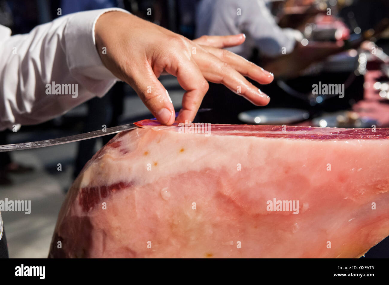 Tranche-maître prend la tranche de jambon ibérique pendant qu'il est coupant Banque D'Images