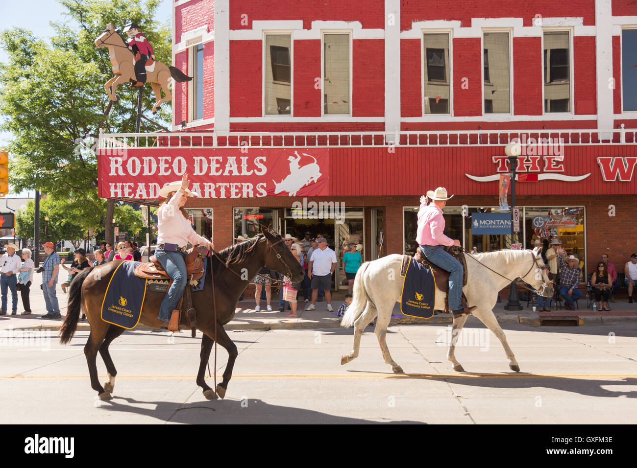 Cowboys à cheval Randonnée passé le Wrangler western wear store au cours de la Cheyenne Frontier Days parade dans la capitale de l'état, le 23 juillet 2015 à Cheyenne, Wyoming. Frontier Days célèbre les traditions de l'ouest cowboy avec un rodéo, défilé et juste. Banque D'Images