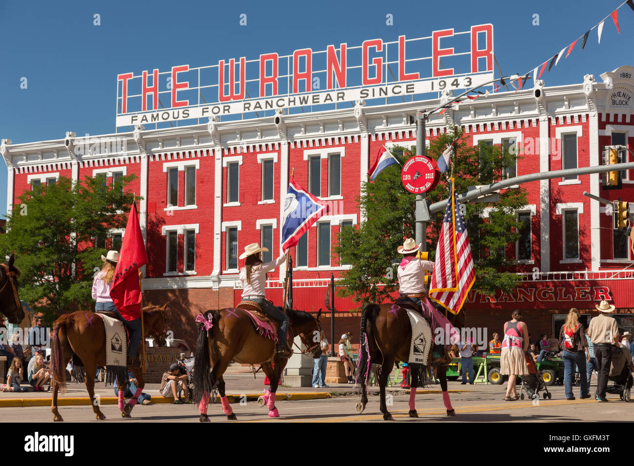 Cowboys à cheval Randonnée passé le Wrangler western wear store au cours de la Cheyenne Frontier Days parade dans la capitale de l'état, le 23 juillet 2015 à Cheyenne, Wyoming. Frontier Days célèbre les traditions de l'ouest cowboy avec un rodéo, défilé et juste. Banque D'Images