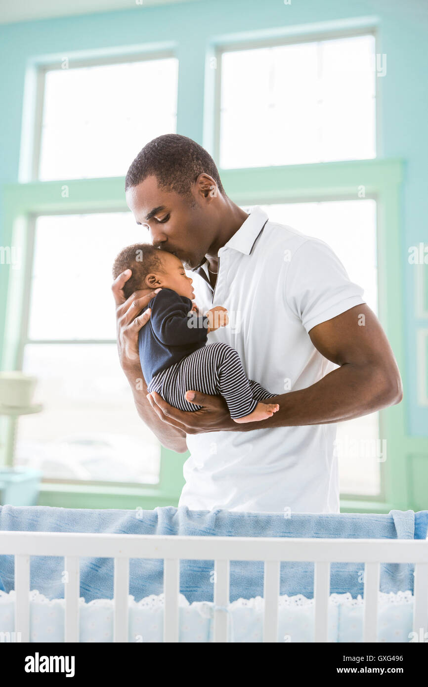 Père noir embrassant bébé fils sur le front Banque D'Images