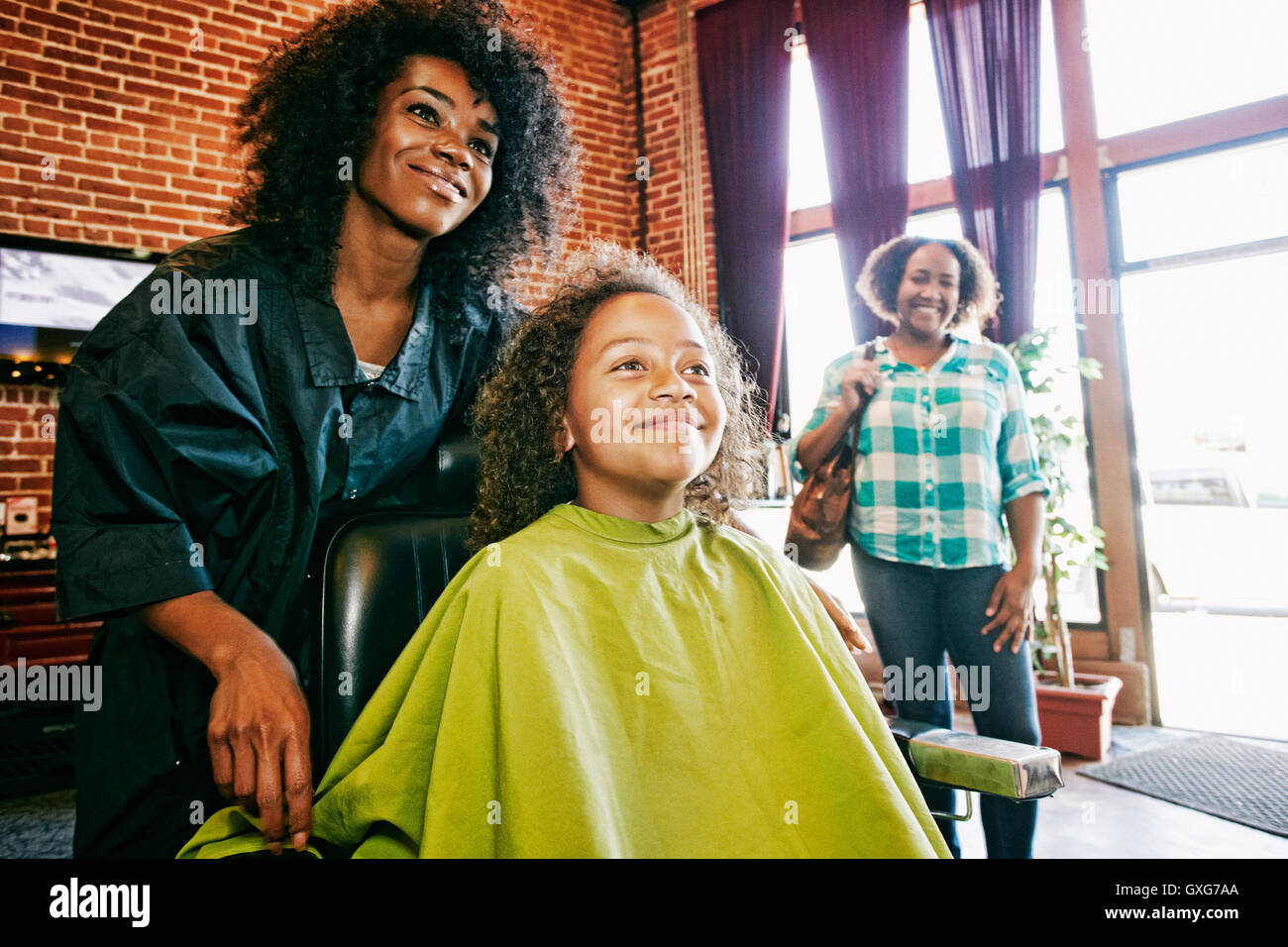 Smiling coiffure et clients dans un salon de coiffure Banque D'Images