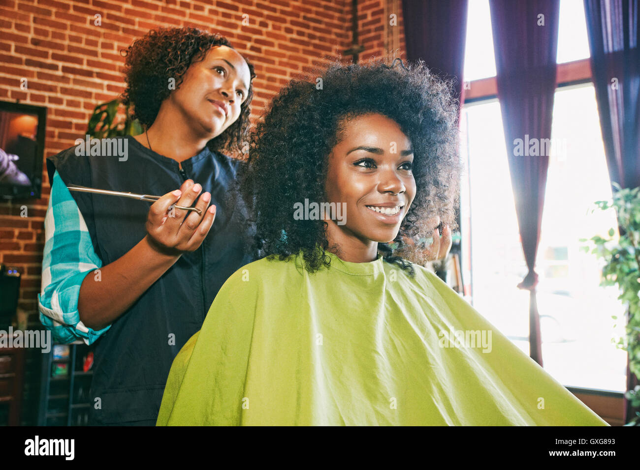 Smiling coiffure et client dans un salon de coiffure Banque D'Images