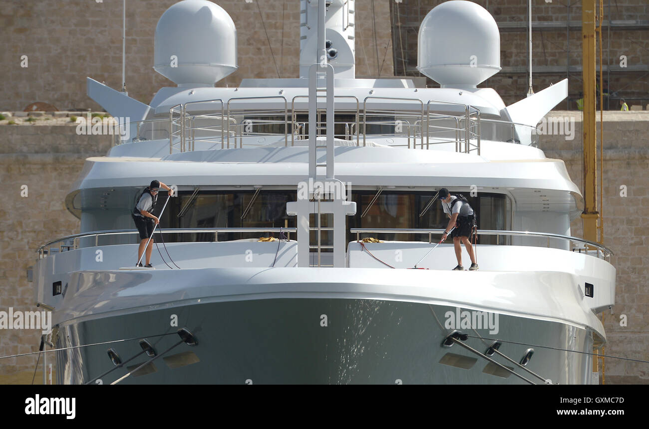 Deux membres d'équipage nettoyer un bateau superyacht à Grand Harbour Marina, Vittoriosa, La Valette, Malte Banque D'Images
