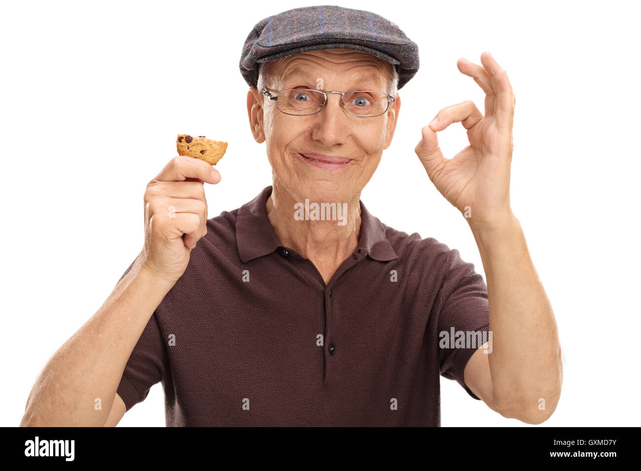 Homme âgé de manger un cookie et en faisant un signe ok isolé sur fond blanc Banque D'Images