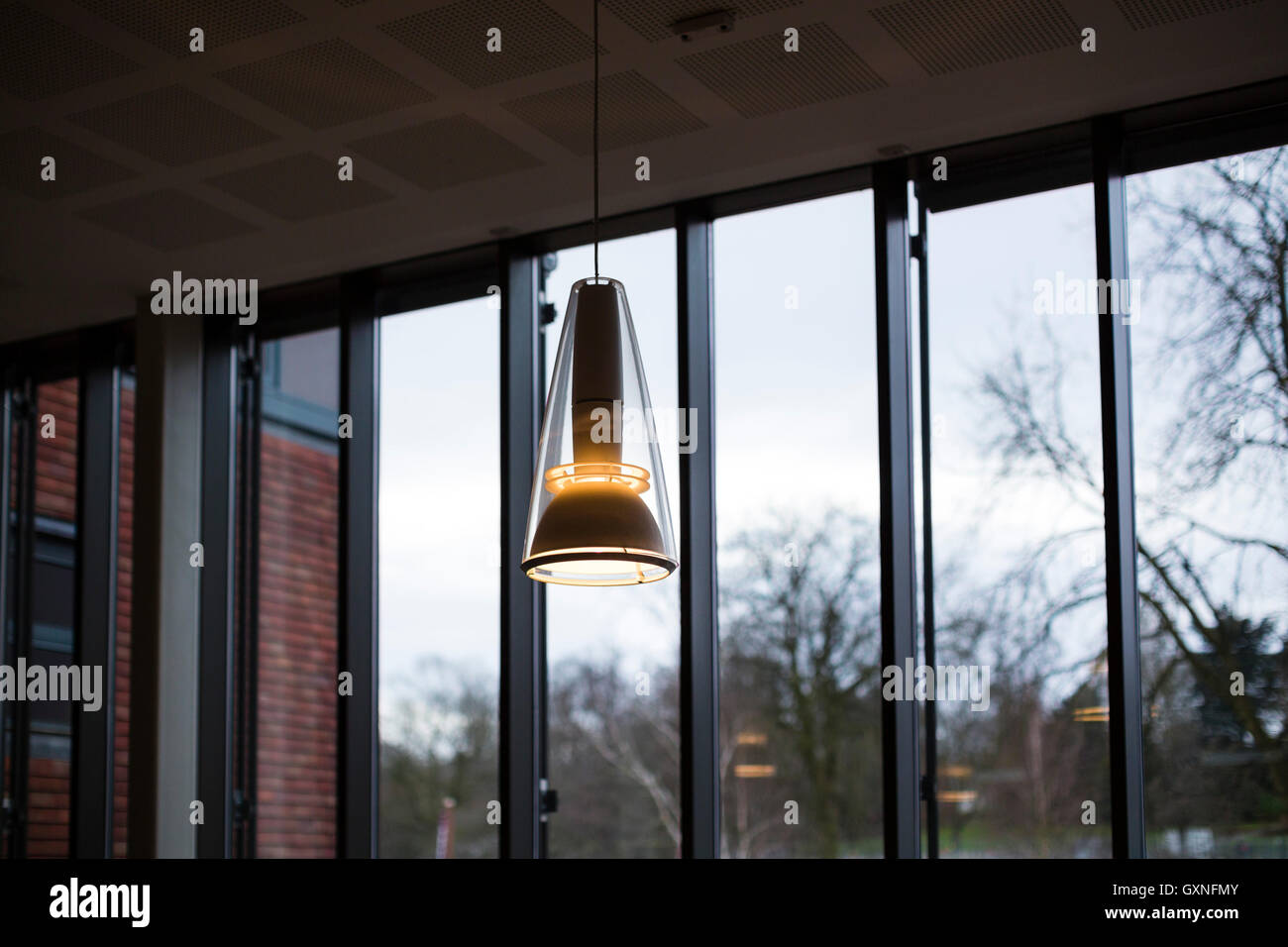 Luminaires suspendus avec l'intérieur de l'adn grand verre fenêtre derrière comme dans une salle de l'environnement. Banque D'Images