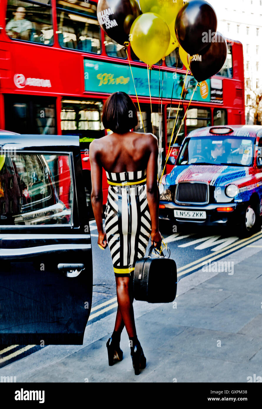 London Fashion Week Février 2013, Belle Mannequin pose avec des ballons au milieu du trafic de Londres, Londres WC2, England, UK Banque D'Images