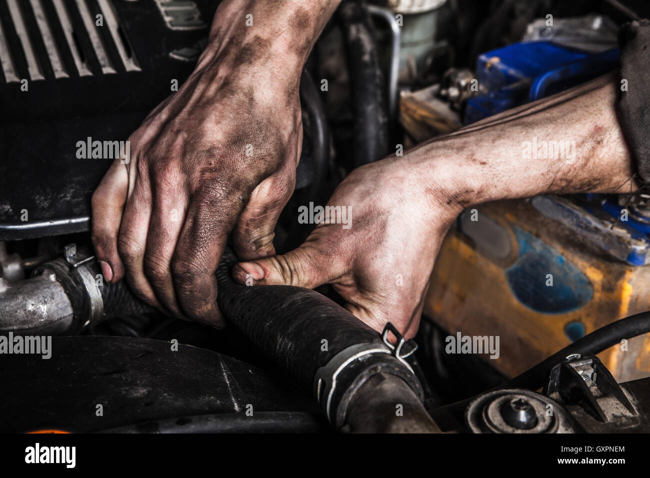 Les hommes qui travaillent avec des mains sales et des outils Banque D'Images