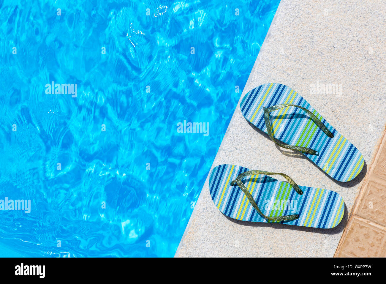 Paire de chaussons de bain sur le bord de piscine bleu Banque D'Images