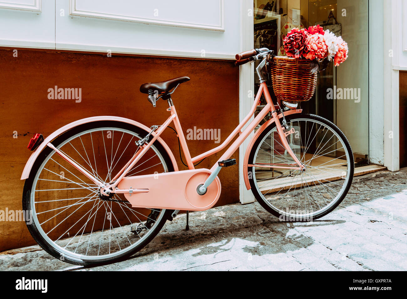 Rose Vintage vélo avec un panier de fleurs décoratives sur le stationnement  dans la rue Ville Européenne Photo Stock - Alamy