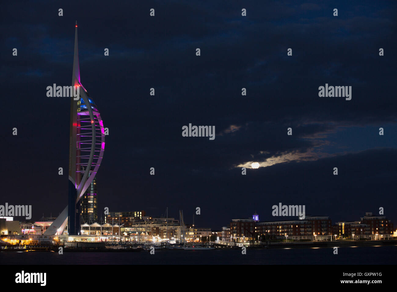 Photo de nuit de la tour du millénaire à Portsmouth Hampshire. Nous avons une récolte pleine lune peeping hors des nuages. Banque D'Images