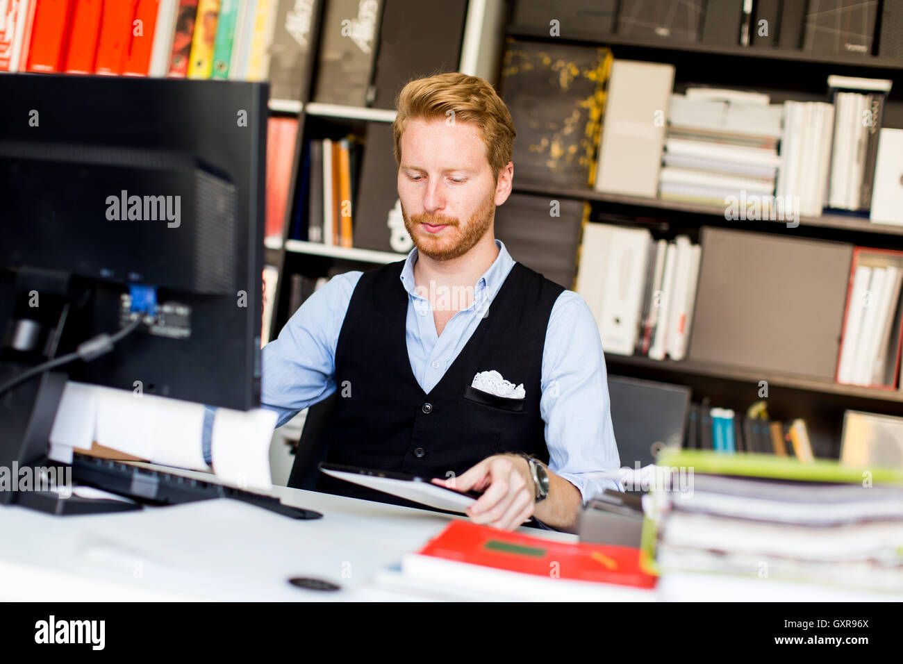 Jeune homme d'affaires réussie at desk in office Banque D'Images