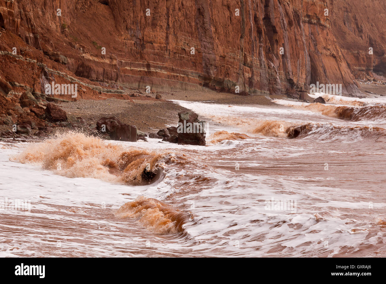 Des vagues d'eau décolorée retrousser la plage à Salcombe Hill près de falaise dans le Devon Sidmouth Banque D'Images