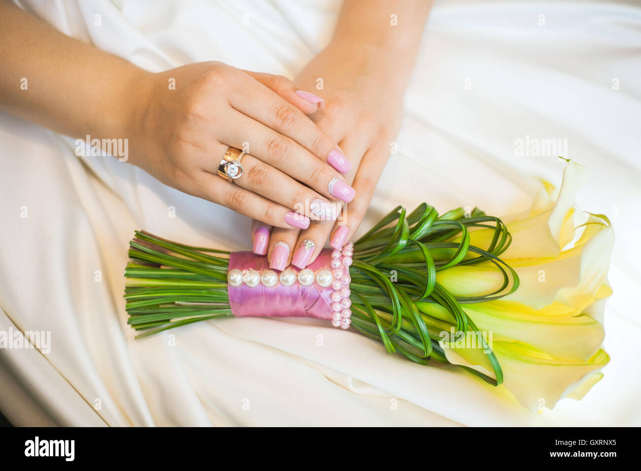 Bride les mains avec l'anneau sur la robe de mariage Banque D'Images
