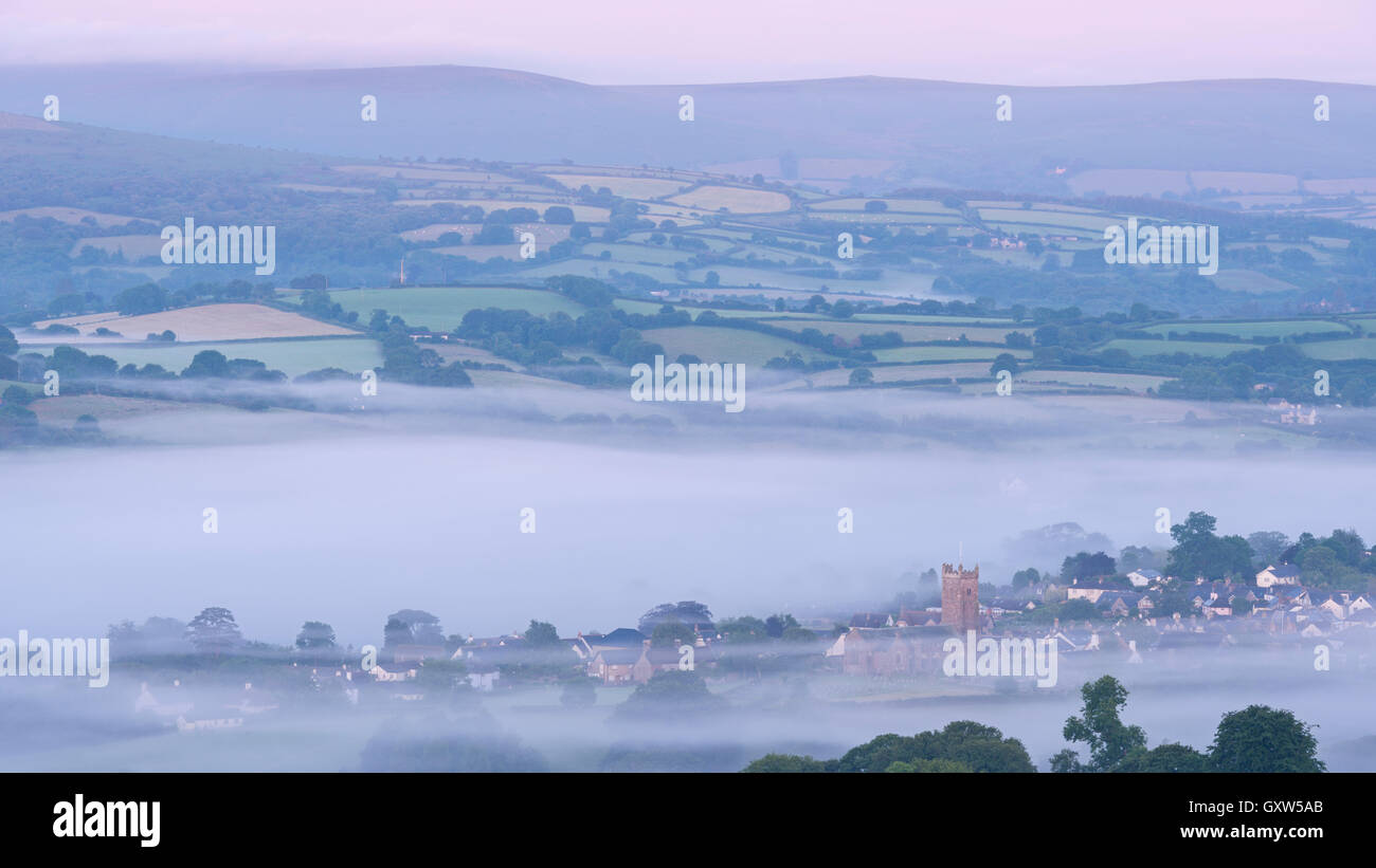 Moretonhampstead ville et l'église à l'aube d'un matin brumeux, Dartmoor National Park, Devon, Angleterre. L'été (juillet) 2015. Banque D'Images