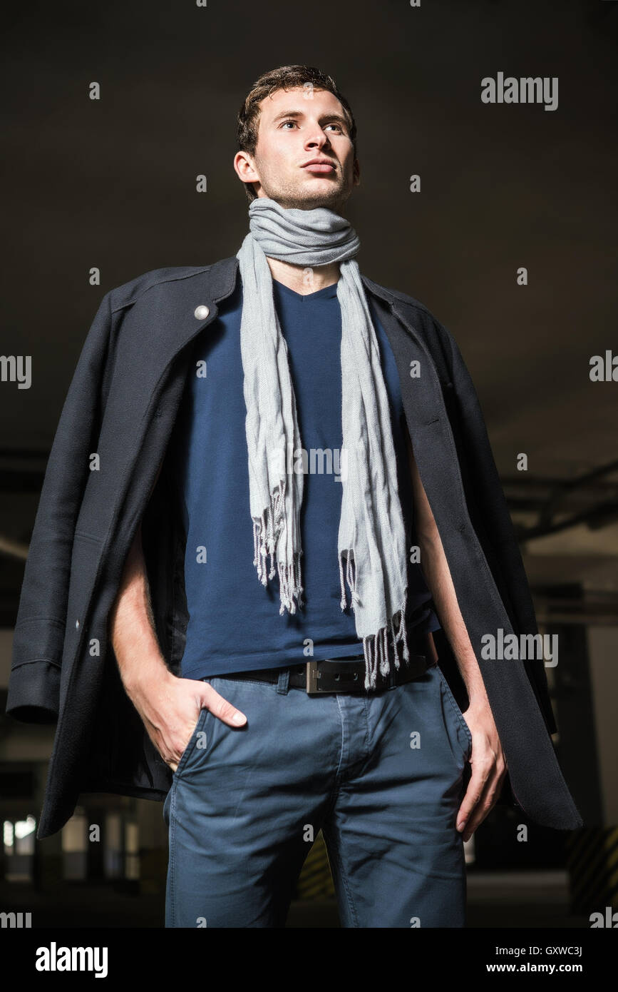 Fashion shot : beau jeune homme portant des jeans, manteau, chemise et foulard Banque D'Images