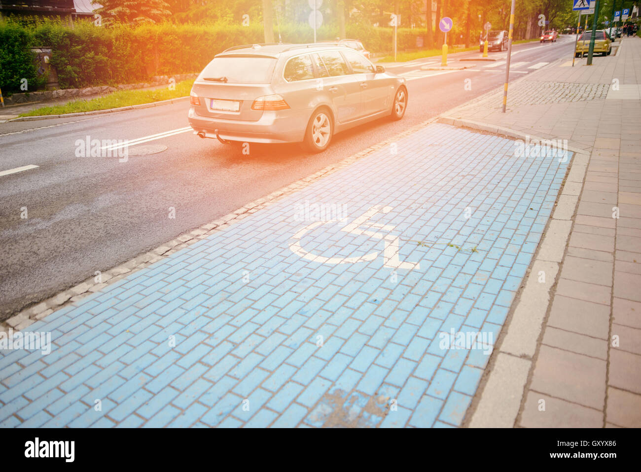 Symbole handicapés International peint en bleu vif sur un espace de stationnement. Banque D'Images