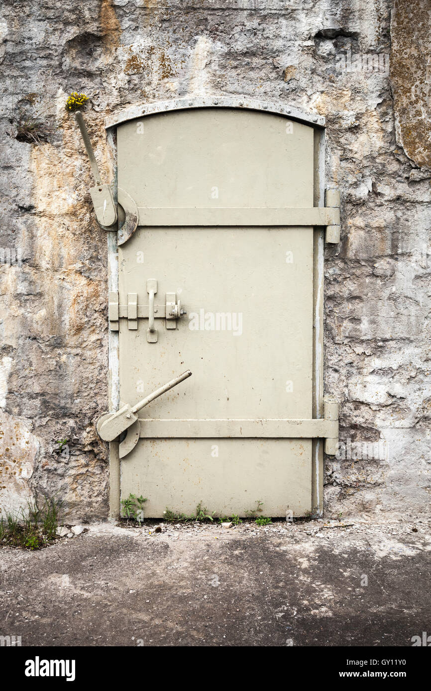Porte en métal massif fermé dans le vieux mur de fortification, texture d'arrière-plan Banque D'Images