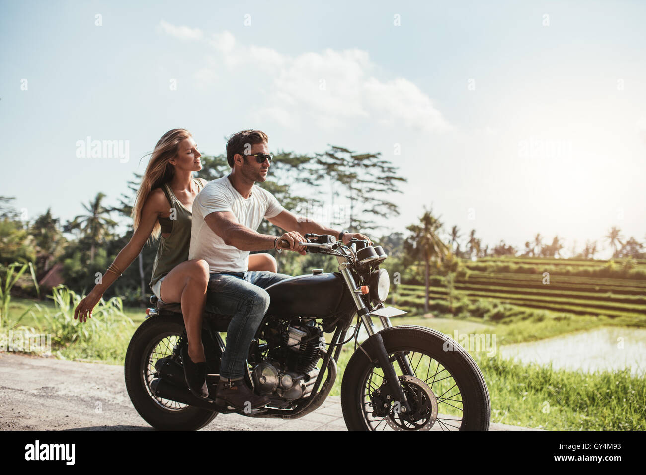 Vue de côté coup de jeune couple en moto. L'homme à cheval sur une moto  avec ma copine on country road Photo Stock - Alamy