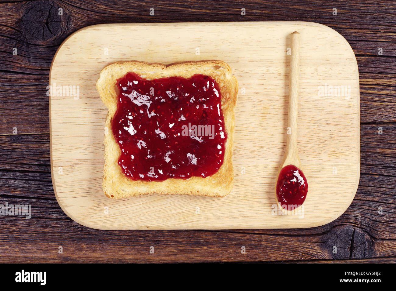 Toasts avec de la confiture et la cuillère sur une planche à découper. Vue d'en haut Banque D'Images
