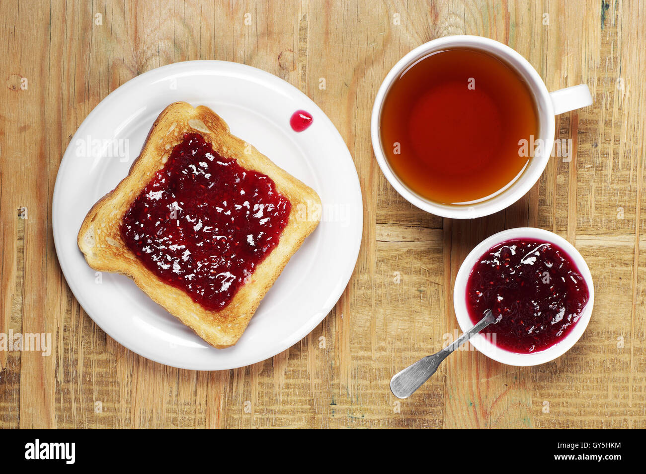 Toasts avec de la confiture et une tasse de thé sur la vieille table en bois. Vue d'en haut Banque D'Images