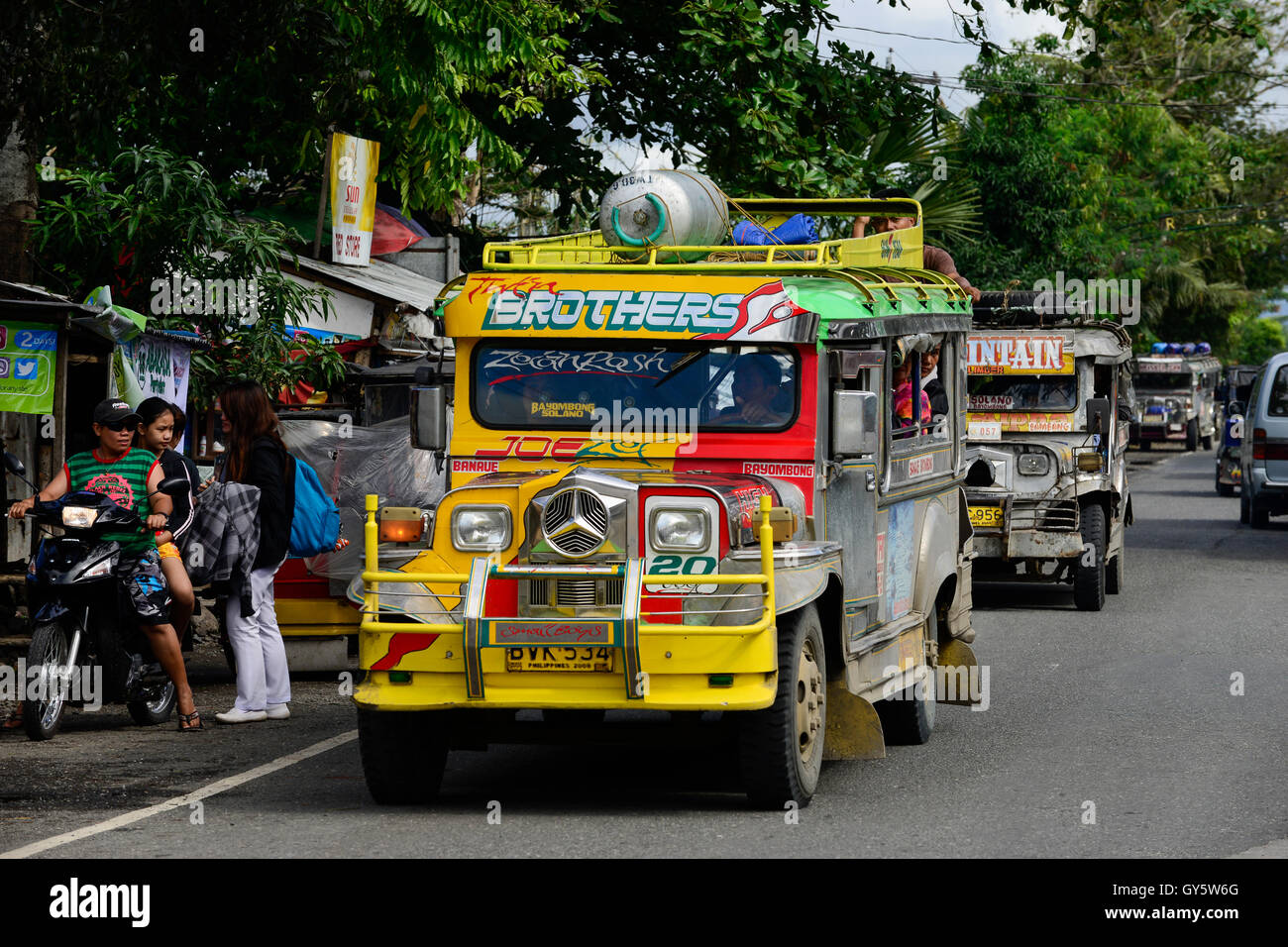 PHILIPPINEN, Province d'Ifugao, Cordilleras, Banaue, Jeepney le transport publicitaire, un minibus bien décoré construit à partir de vieilles jeeps de l'armée américaine, peint en jaune avec étoile Mercedes Benz allemande / PHILIPPINEN, Province d'Ifugao, Cordilleras, Jeepney das lokale Transportmittel Banque D'Images