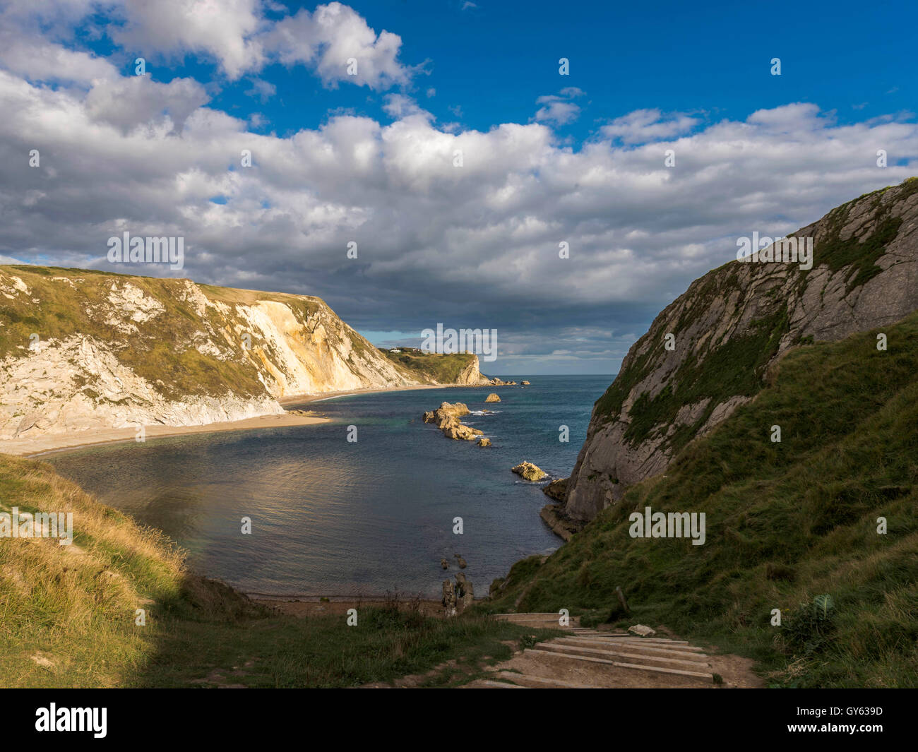 Représentant le paysage des rives de galets sur une belle journée d'été avec la plage Man O'War en arrière-plan. Banque D'Images