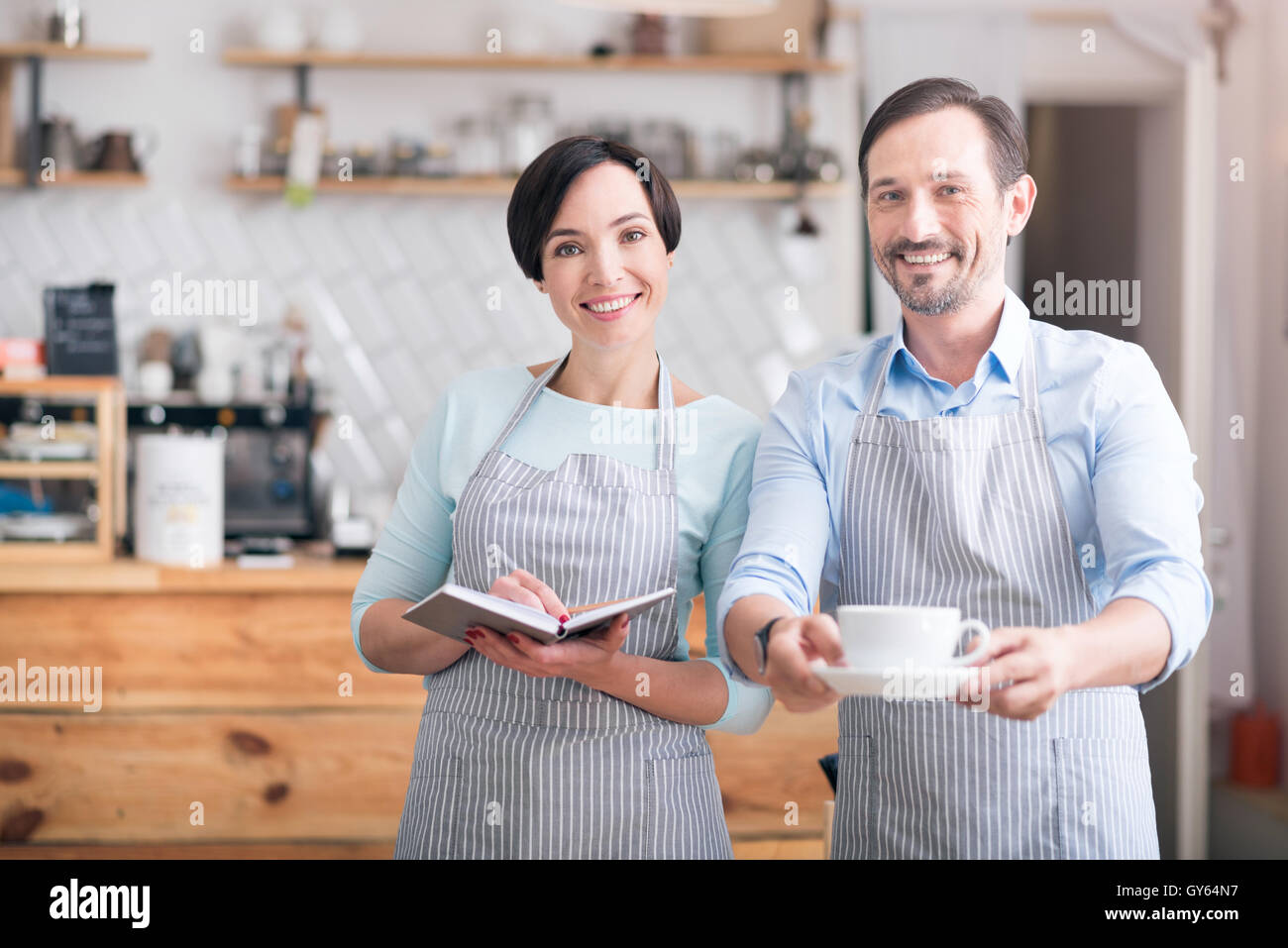Deux serveurs en tabliers standing in cafe Banque D'Images