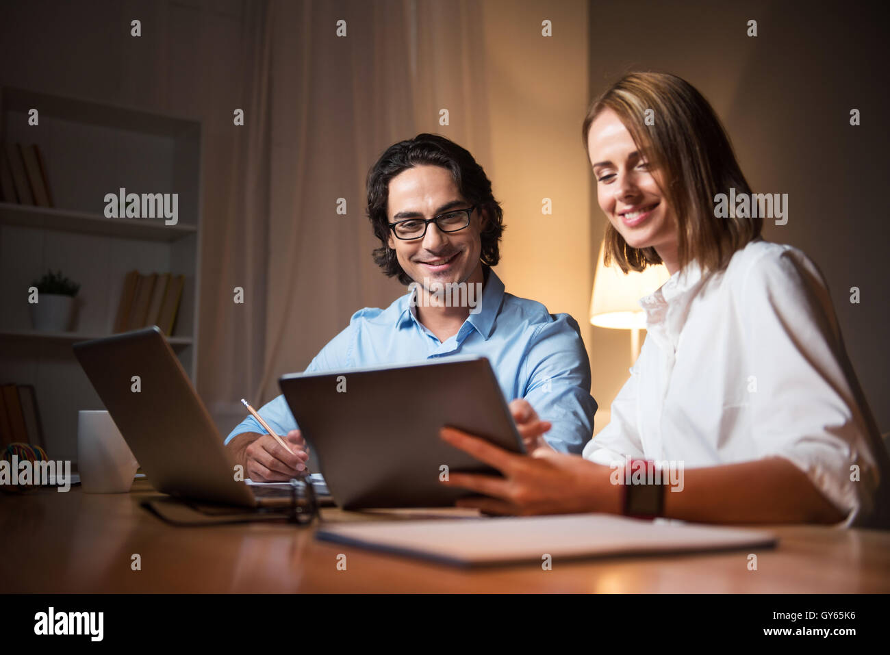 Femme joyeuse de partager des idées avec son collègue Banque D'Images