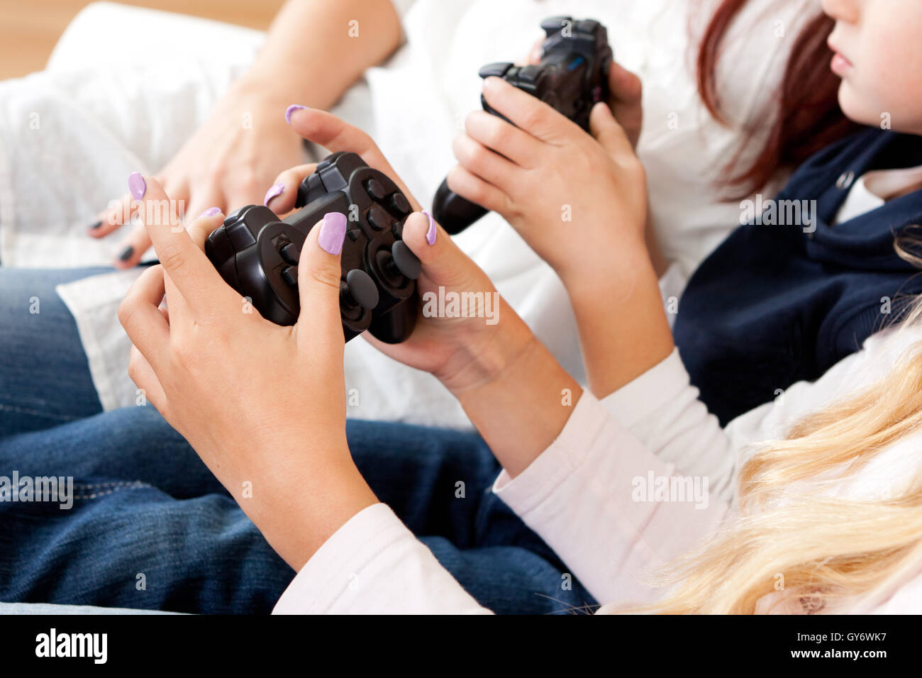 Les enfants jouant les jeux de console à l'aide de joystick Banque D'Images