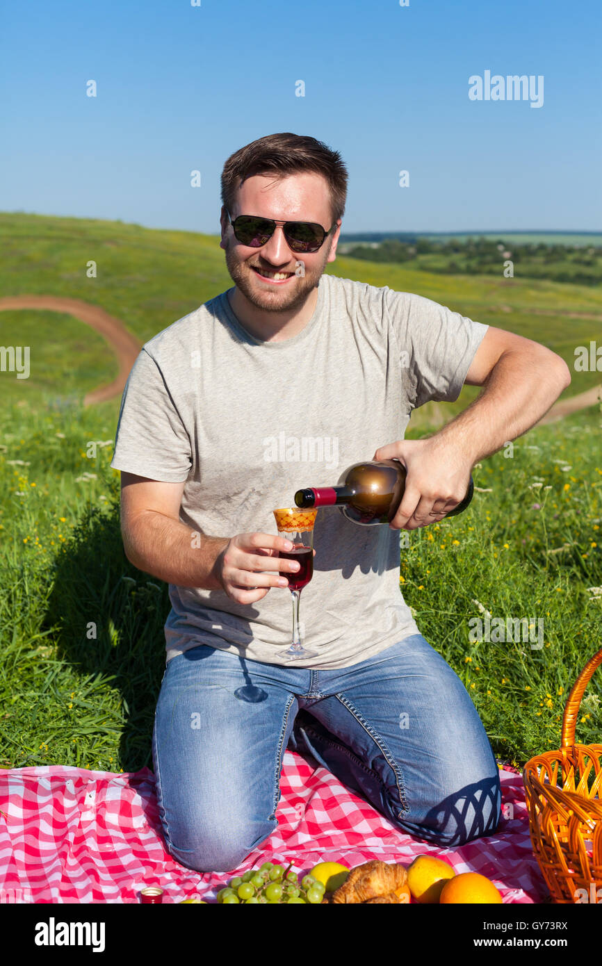 L'homme de boire du vin sur le pique-nique Banque D'Images