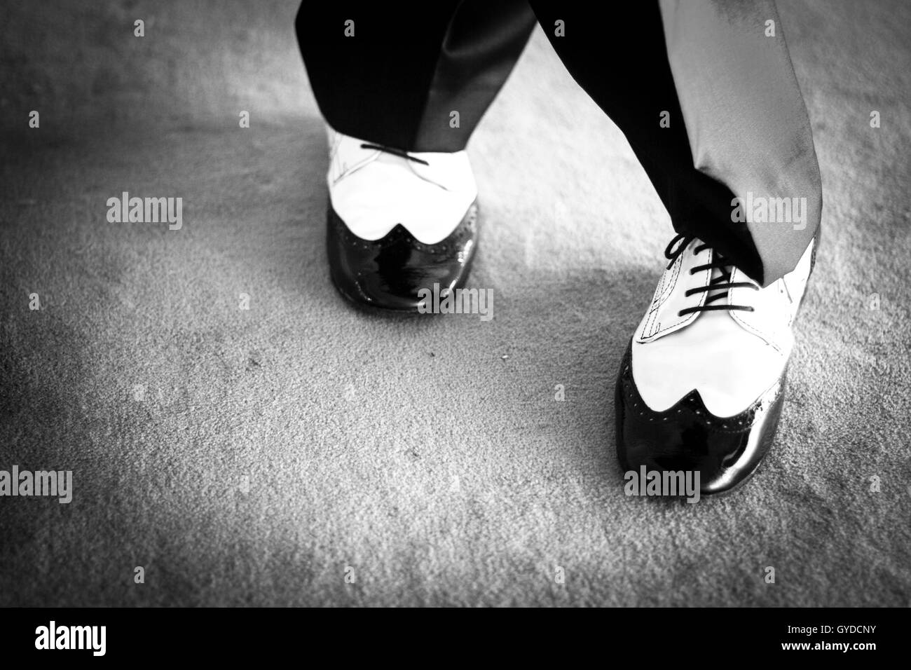 L'homme danseur de salsa et en noir et blanc chaussures de danse jazz dans la lumière et l'obscurité sur scène photo monochrome. Banque D'Images