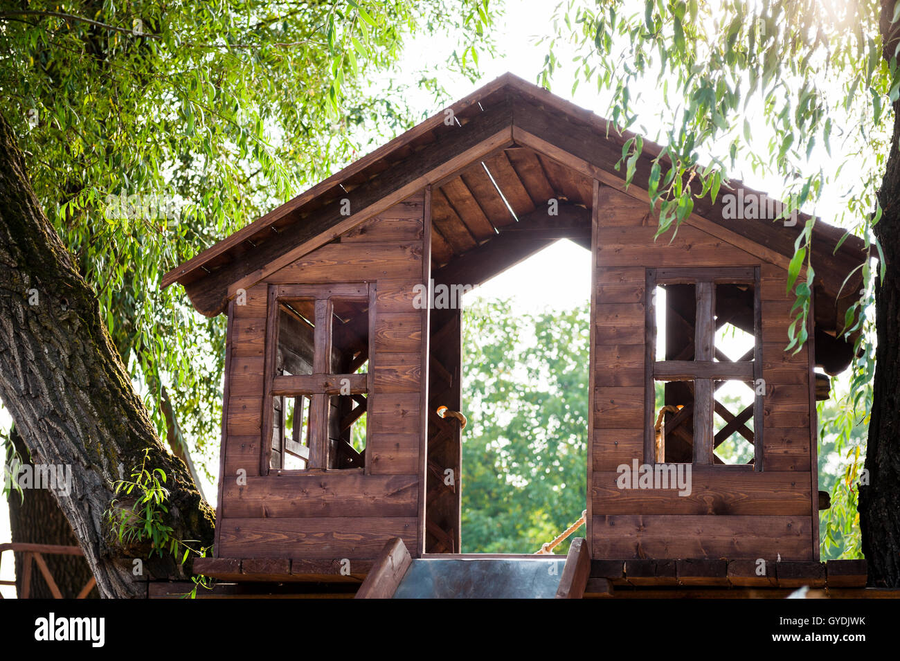 Maison de l'arbre avec une diapositive sur l'aire de jeux dans la journée Banque D'Images Maison de l'arbre avec une diapositive sur l'aire de jeux dans la journée Banque D'Images