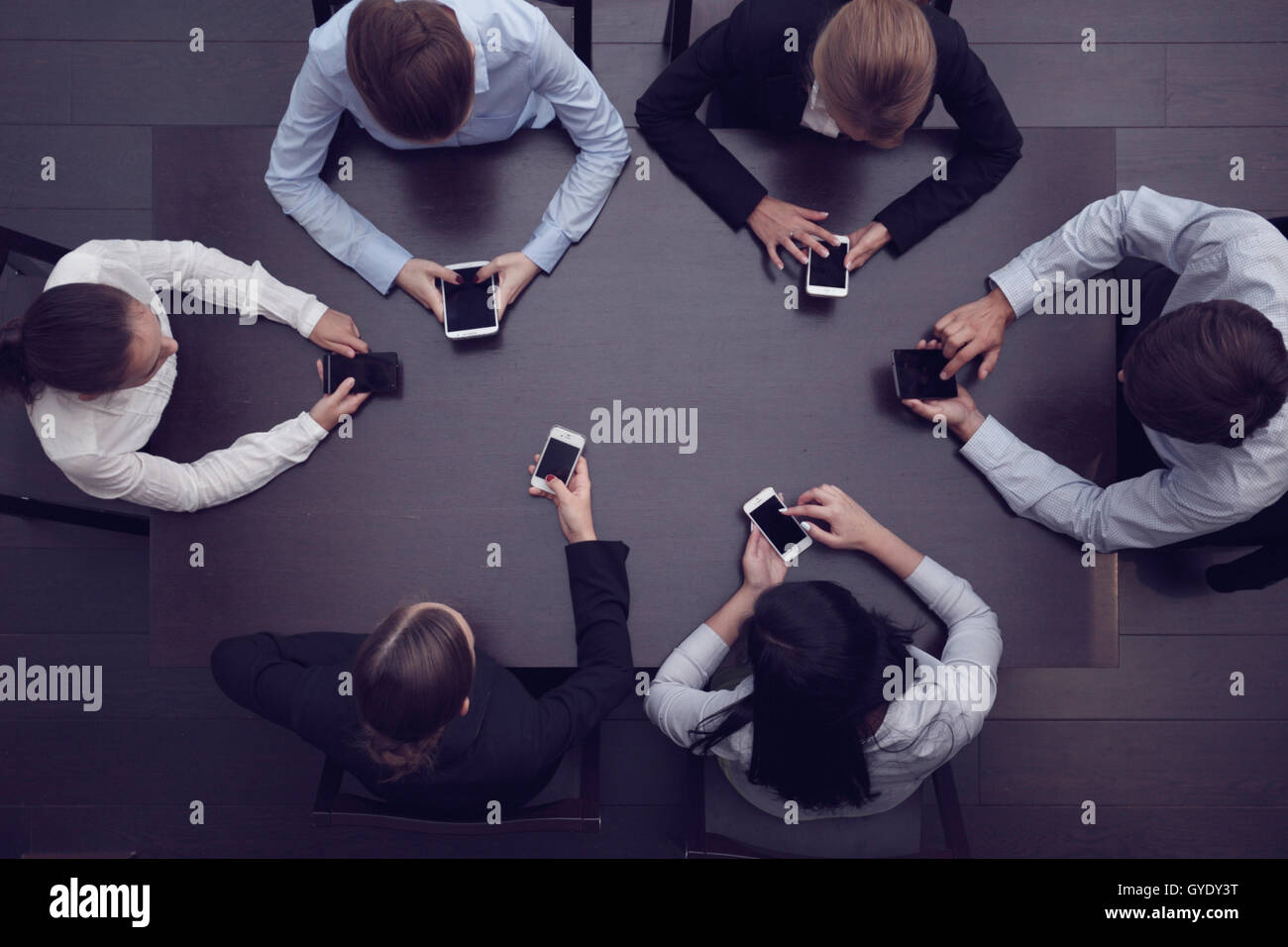 Les gens d'affaires avec les smartphones assis autour de la table, vue du dessus Banque D'Images
