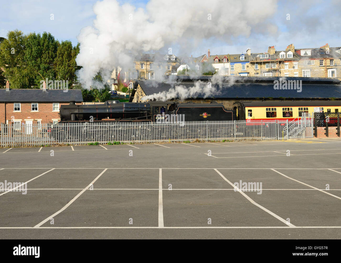 Train à vapeur sur le North Yorkshire Moors Railway, quitter Whitby à côté d'un parking vide. Banque D'Images