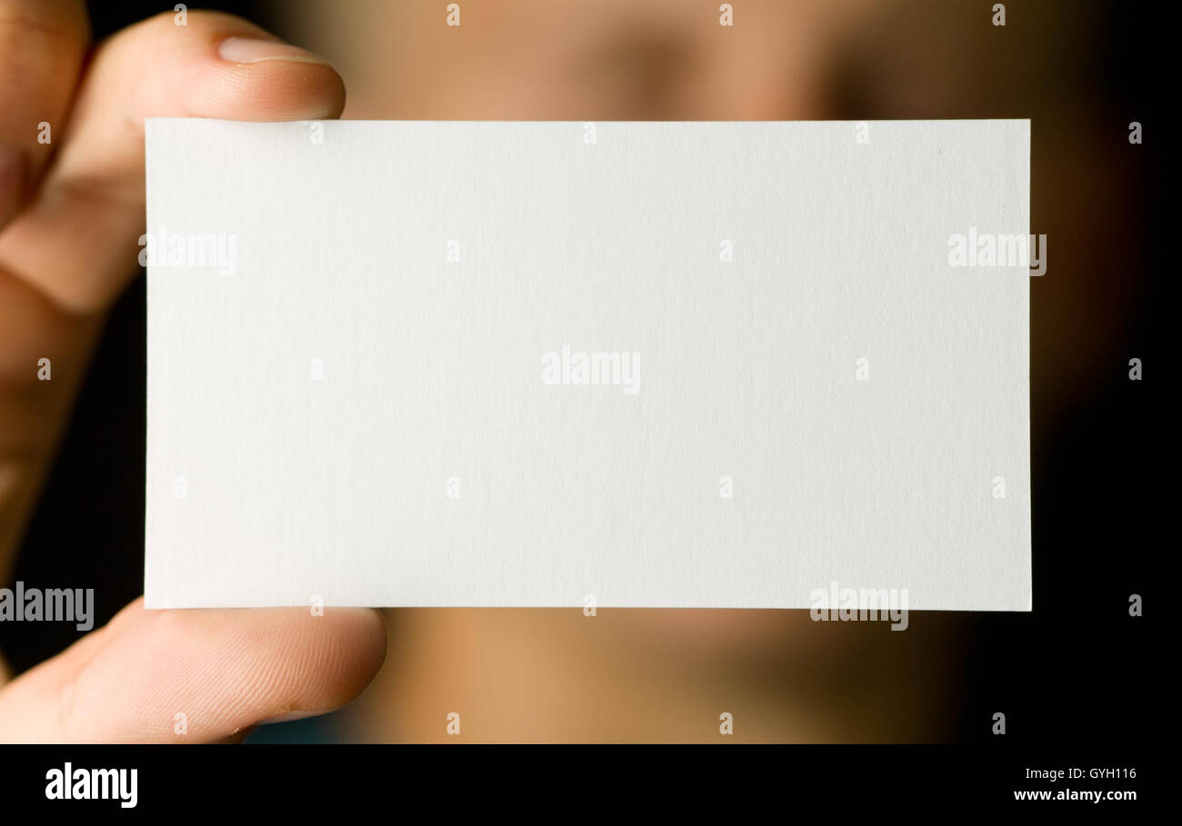 Close-up of man holding blank modèle de carte de visite blanc isolé sur fond noir - Banque D'Images