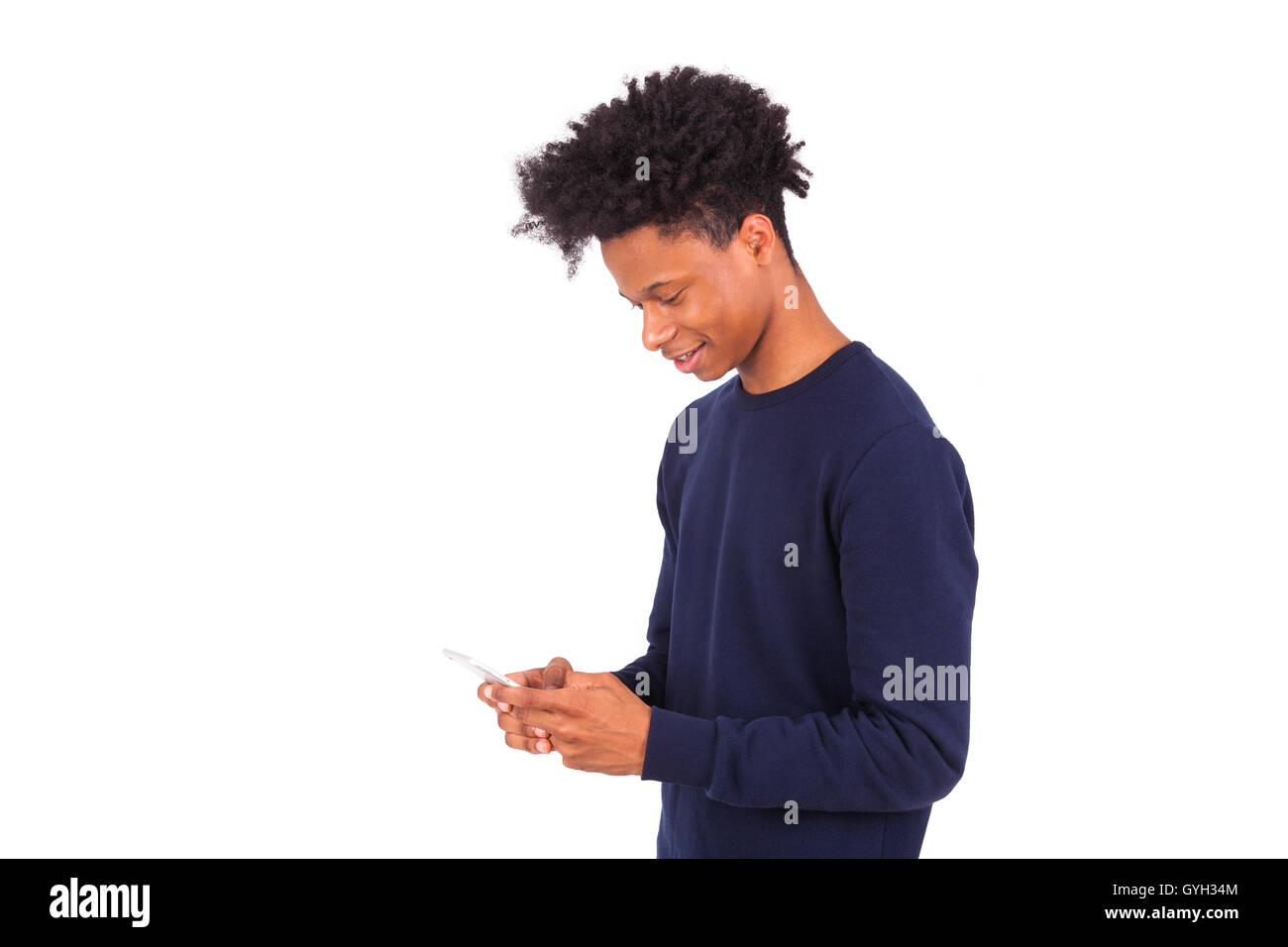 Young African American man de l'envoi d'un message texte SMS sur son smartphone - adolescent noir personnes Banque D'Images