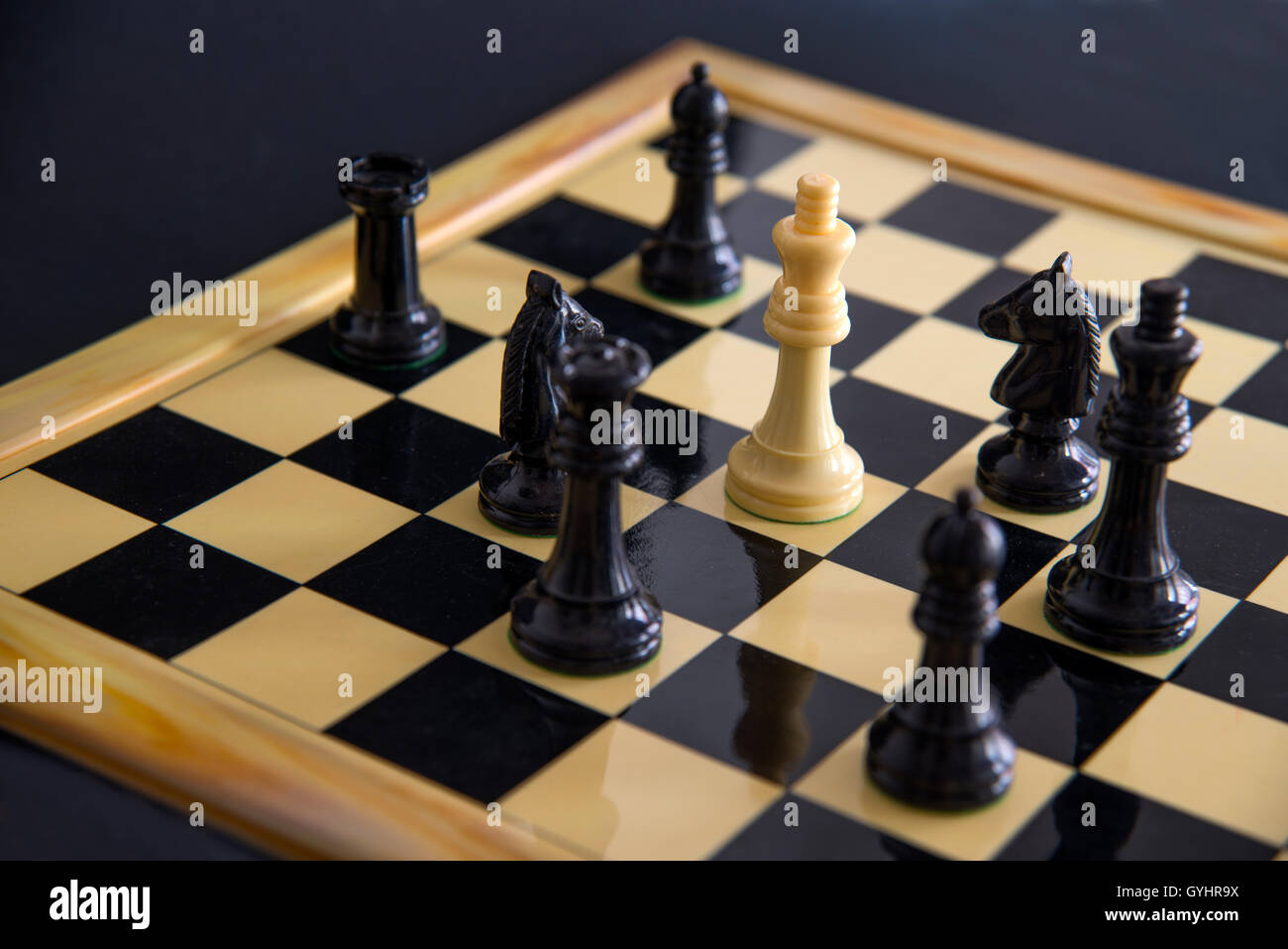 Pièces d'échecs noir entourant le roi blanc. Voir de très près. Banque D'Images