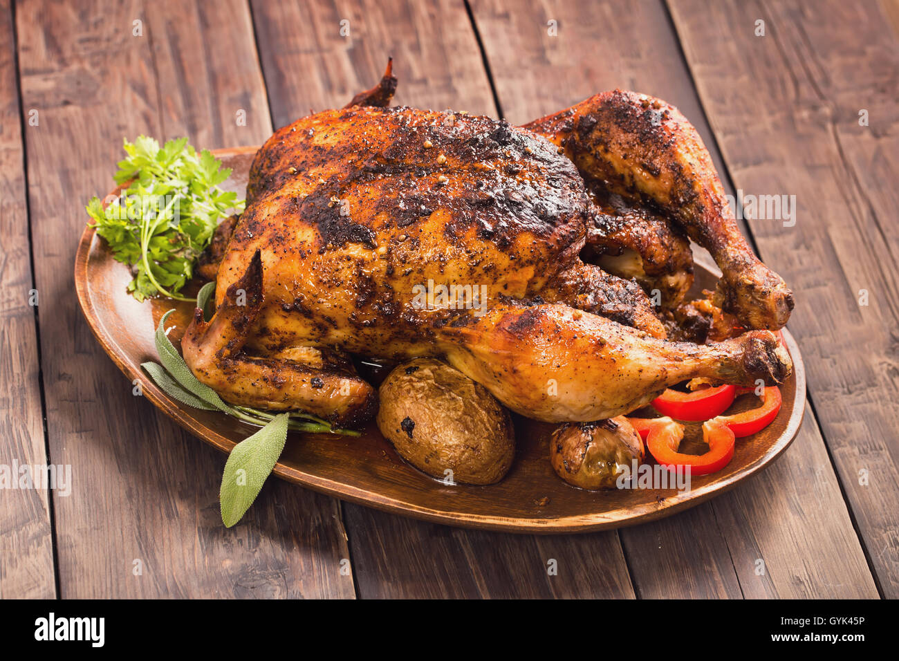 Poulet grillé épicé sur plaque de bois Banque D'Images