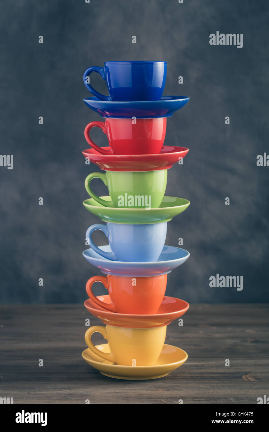 Pile de six tasses multicolores sur table Banque D'Images