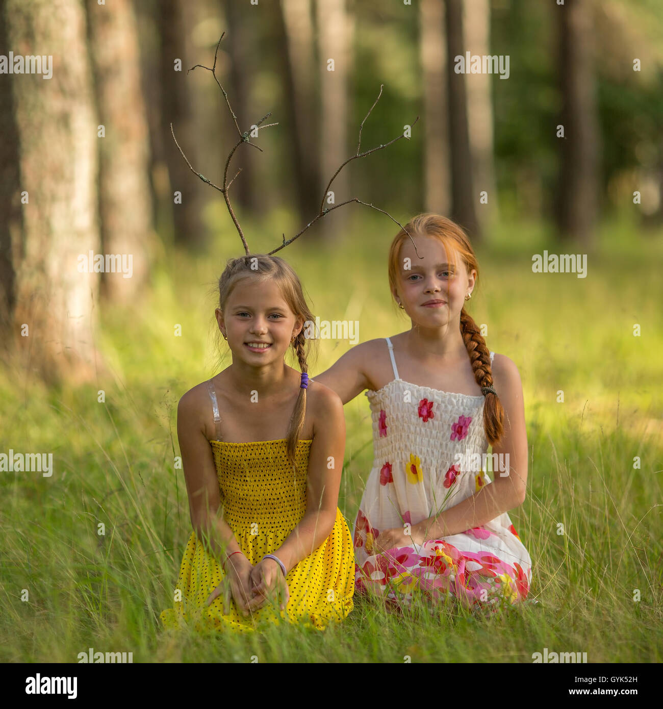 Deux petites filles soeurs posent pour la caméra dans les bois. Banque D'Images