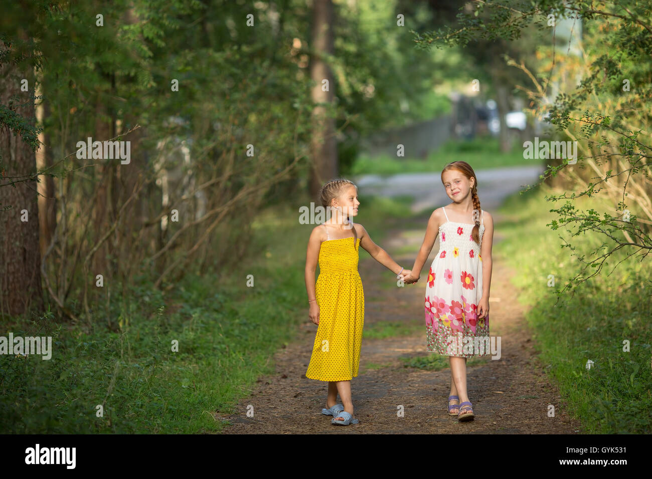 Deux petites filles vont à la poignée sur l'Allée Verte. Banque D'Images