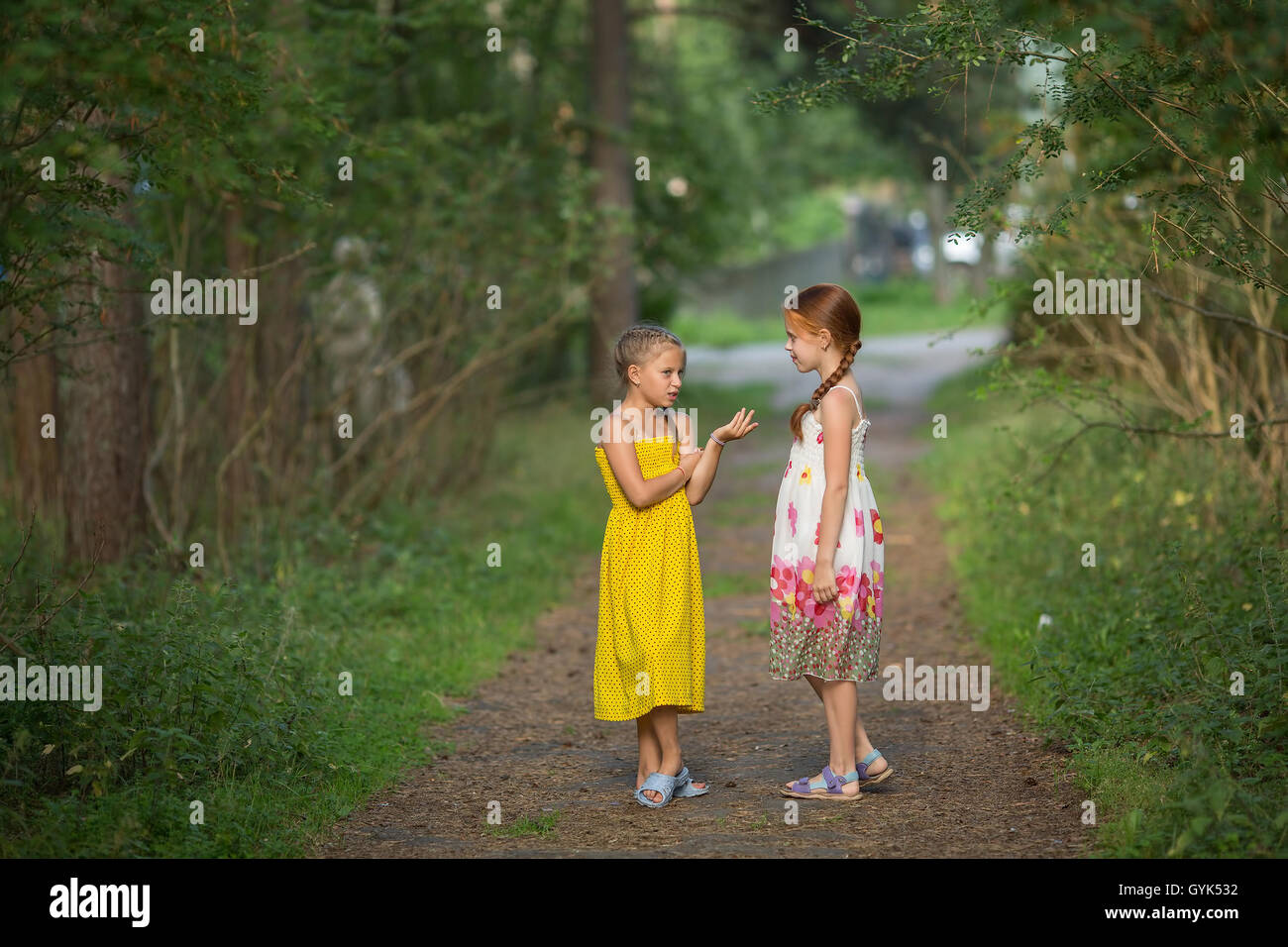 Cute little girls parle avec enthousiasme à l'Allée Verte. Banque D'Images