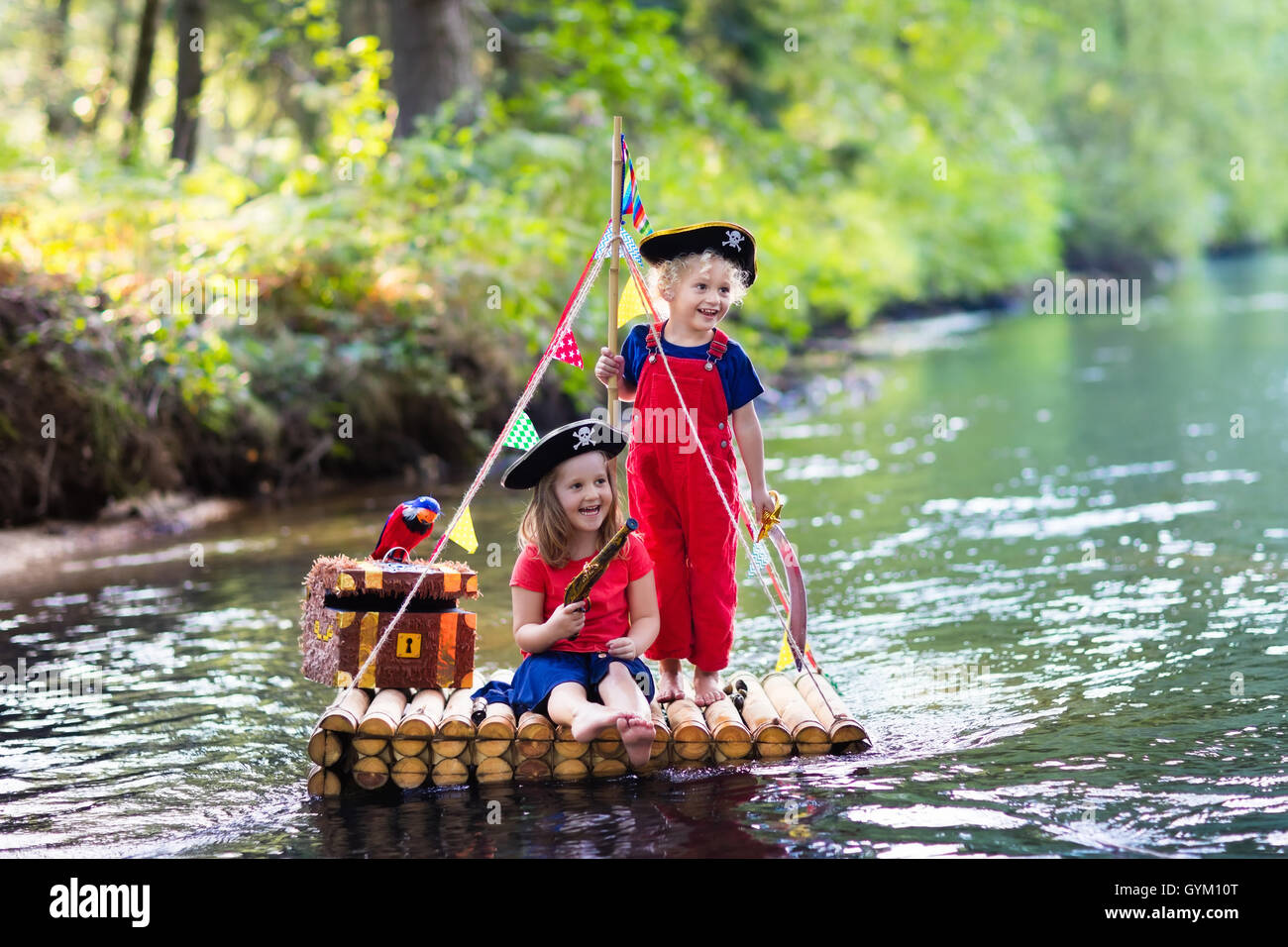Les enfants vêtus de costumes et chapeaux de pirate avec coffre au trésor,  spyglasses, et des épées en bois à jouer sur radeau dans une rivière Photo  Stock - Alamy