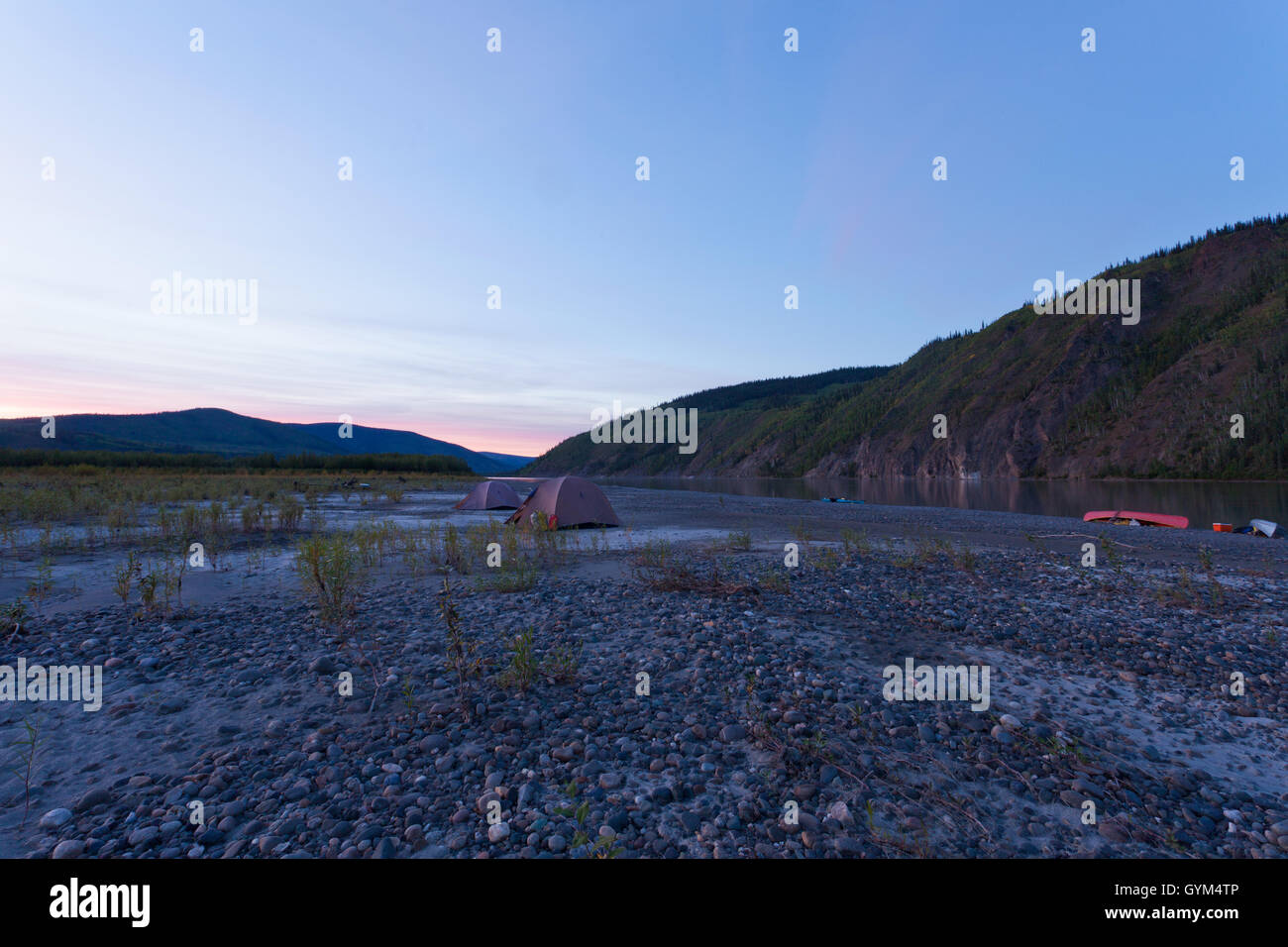 Yukon midsummer night camp de tentes et de canots échoués Banque D'Images