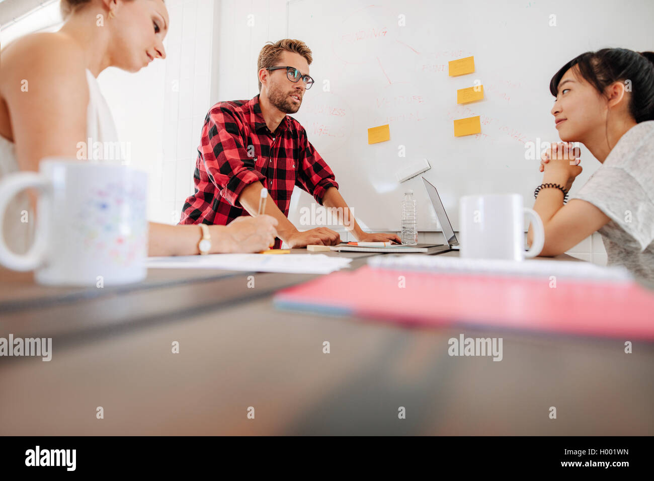 Groupe de discussion sur les cadres de démarrage de nouvelles idées d'affaires au cours d'une réunion en milieu de travail moderne. Employés autour d'une table de réunion Banque D'Images