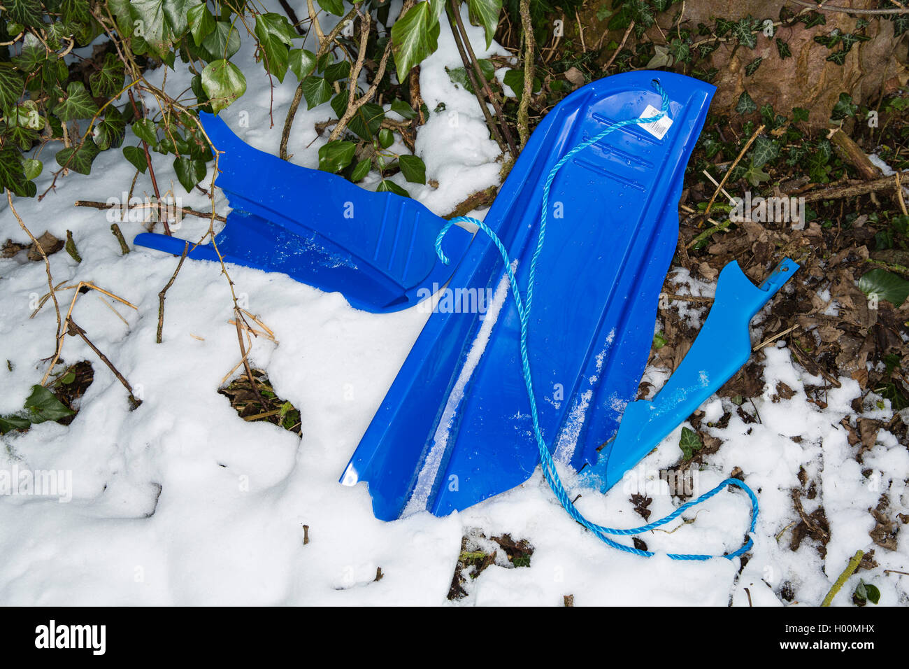 Traîneaux cassés, plateaux et autres morceaux d'ordures jonchent les amphithéâtre romain de Cirencester, Gloucestsershire Uk. Les articles ont été laissés après des jours de la luge et jouer dans la neige, laissant le domaine à la recherche comme un champ de bataille. Banque D'Images