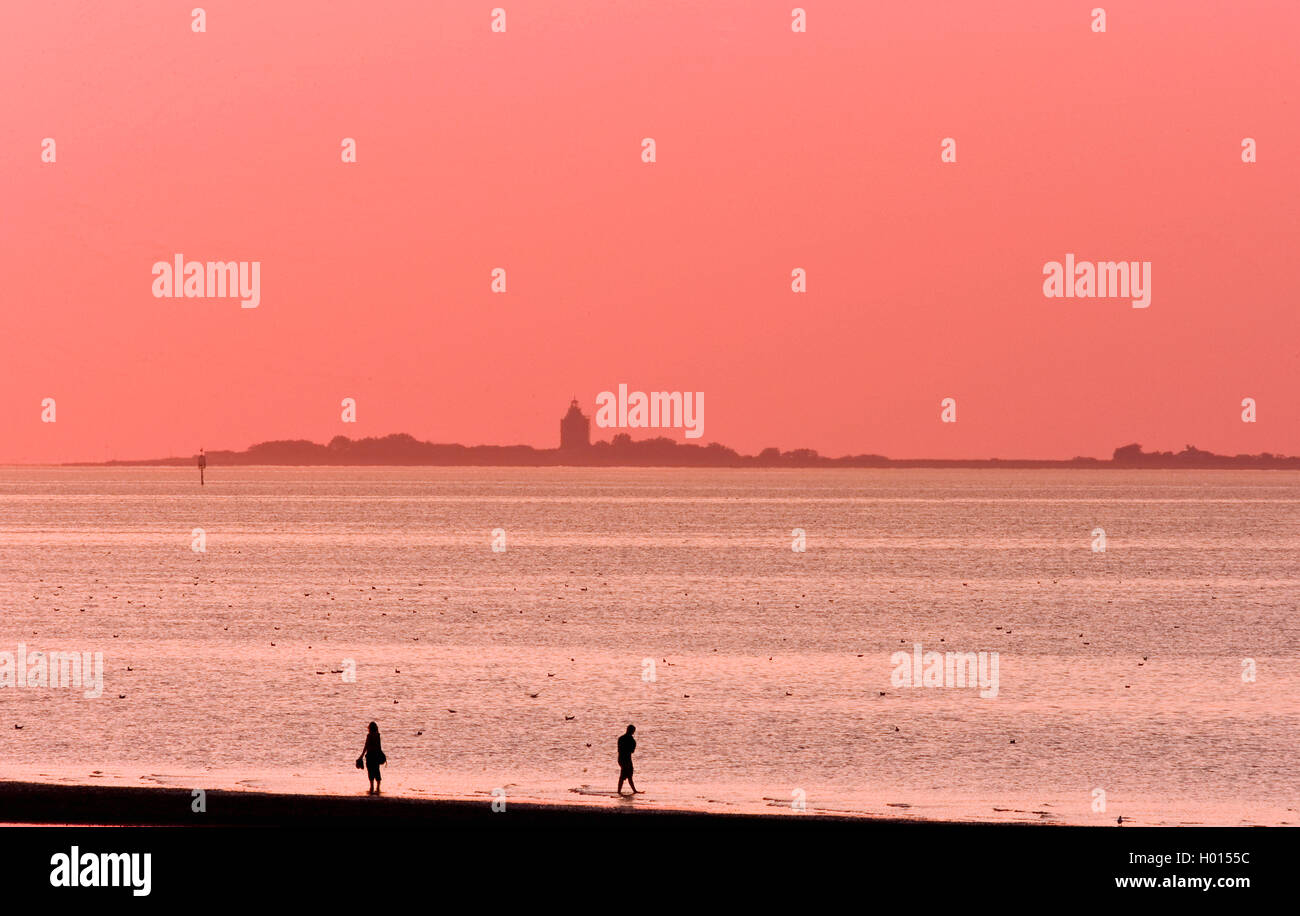 Deux personnes dans la mer des Wadden en face de la mer des Wadden en soirée, l'Allemagne, l'Hamburgisches Wattenmeer National Park Banque D'Images